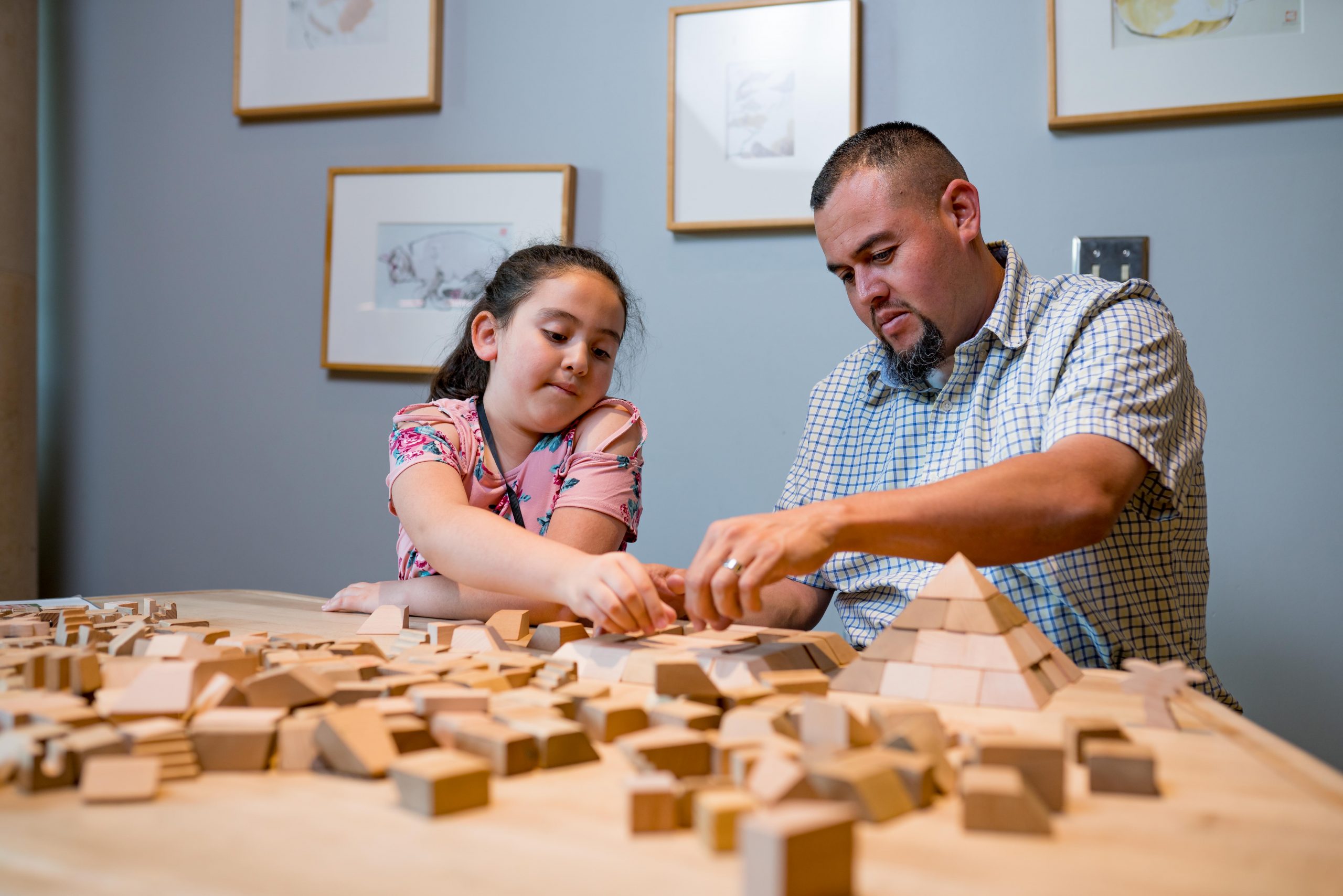 Children and a docent interacting with a digital math exhibit