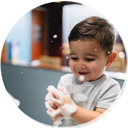 Decorative image of a young child playing with bubbles.