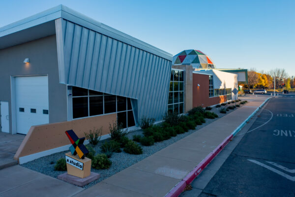 Exterior of X Studio Building with the view of the trades yard garage doors and the length of the building leading up to the Tiguex Park